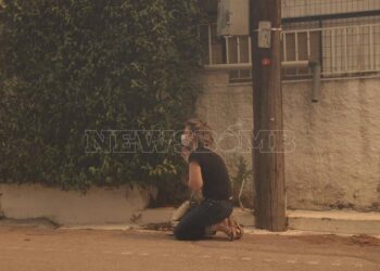 Συγκλονιστική εικόνα: Γυναίκα προσεύχεται βλέποντας τις φλόγες να πλησιάζουν το σπίτι της