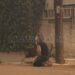 Συγκλονιστική εικόνα: Γυναίκα προσεύχεται βλέποντας τις φλόγες να πλησιάζουν το σπίτι της